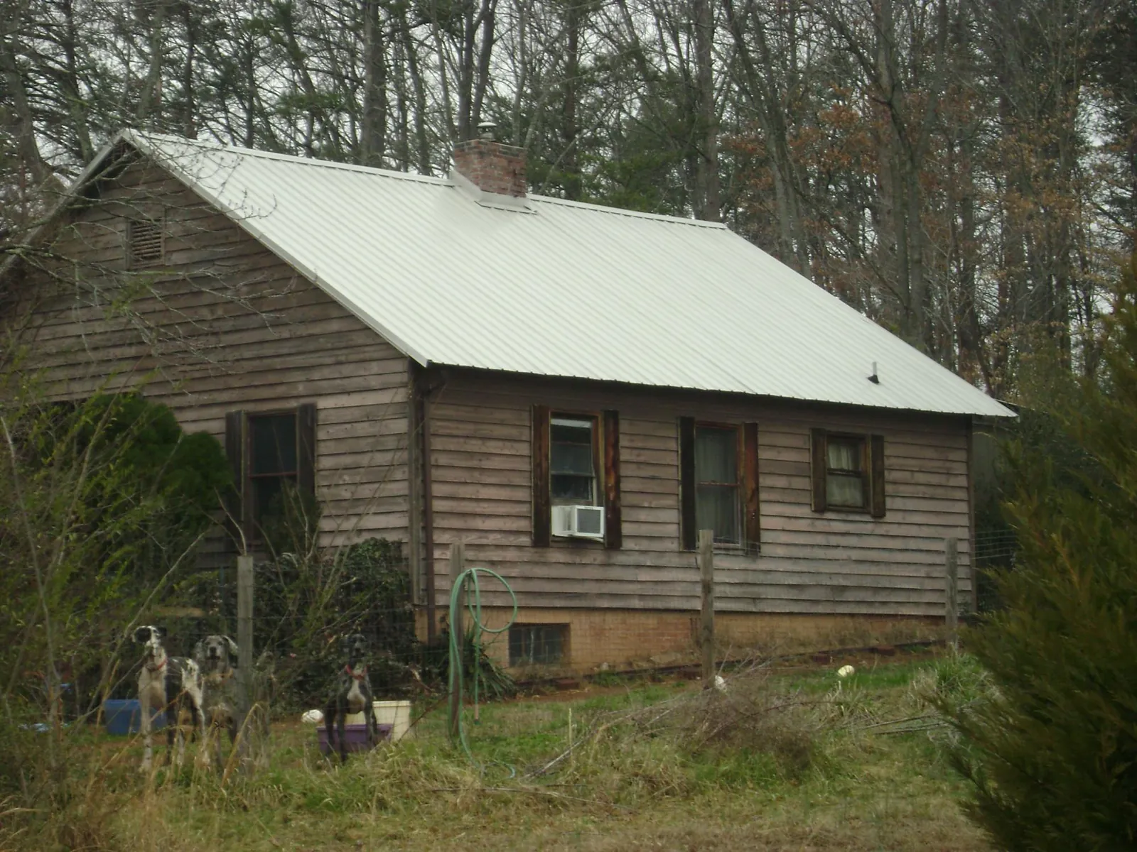 White metal roof on an old wood sided farmhouse, from a Metal Roof Installation job in Custer